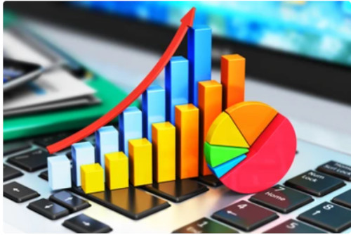 Imagen de gráficos de barras y un gráfico circular sobre un teclado, representando conceptos de estadística para machine learning y análisis de datos.